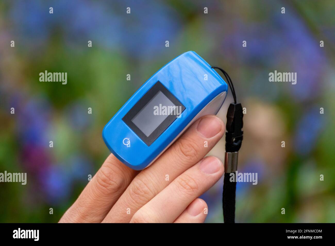 Pulse oximeter with no text on a finger. Blue oxygen saturation meter ...