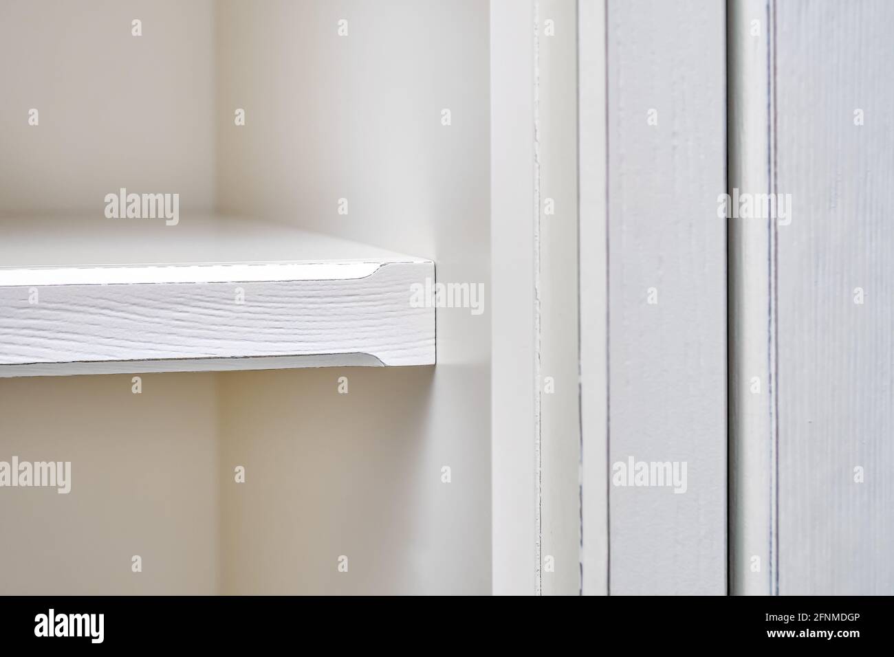 Wooden white shelf of classical wardrobe extreme closeup Stock Photo