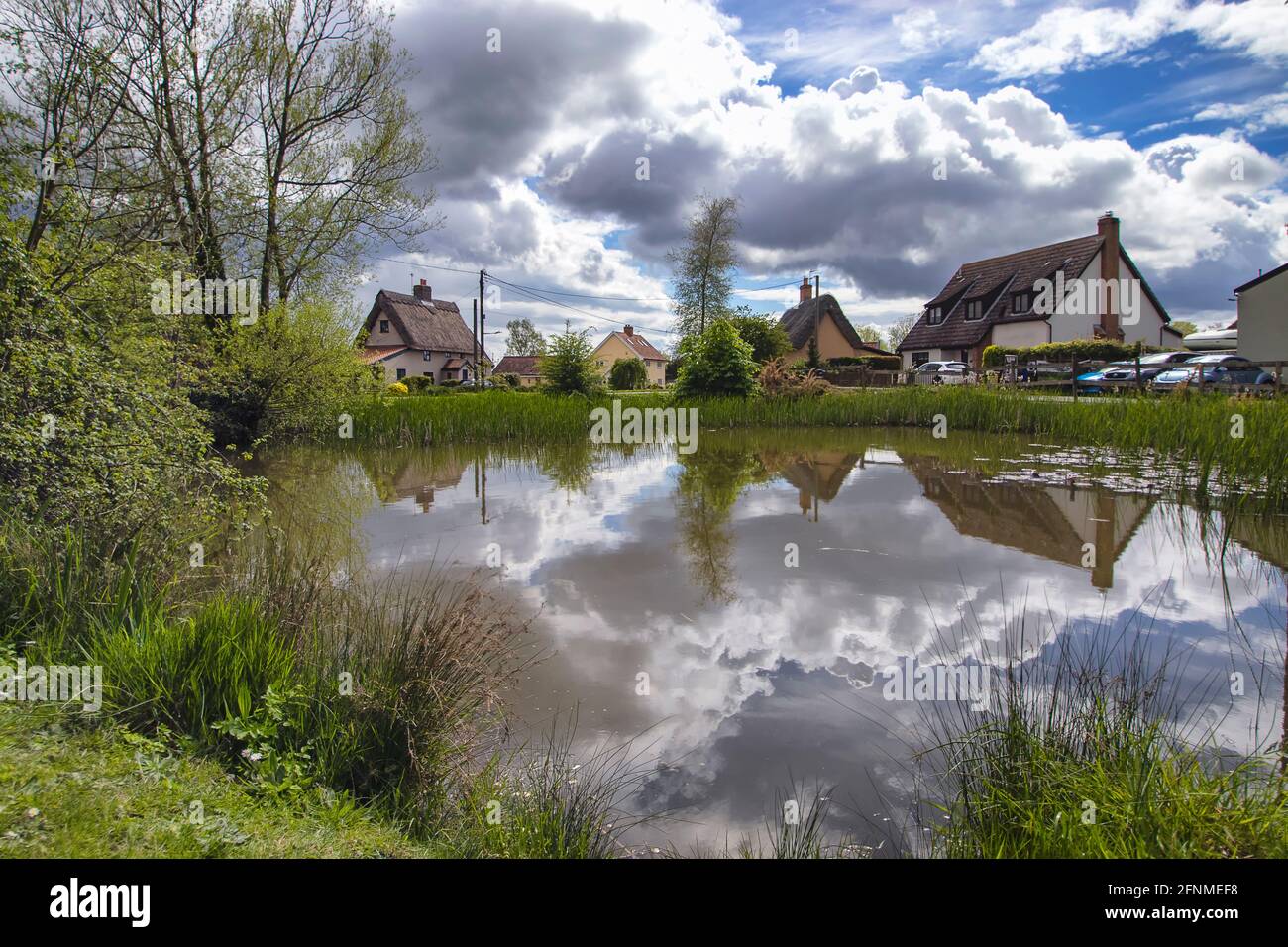 Reflections in the duck pond in the village of Bacton in Suffolk, UK