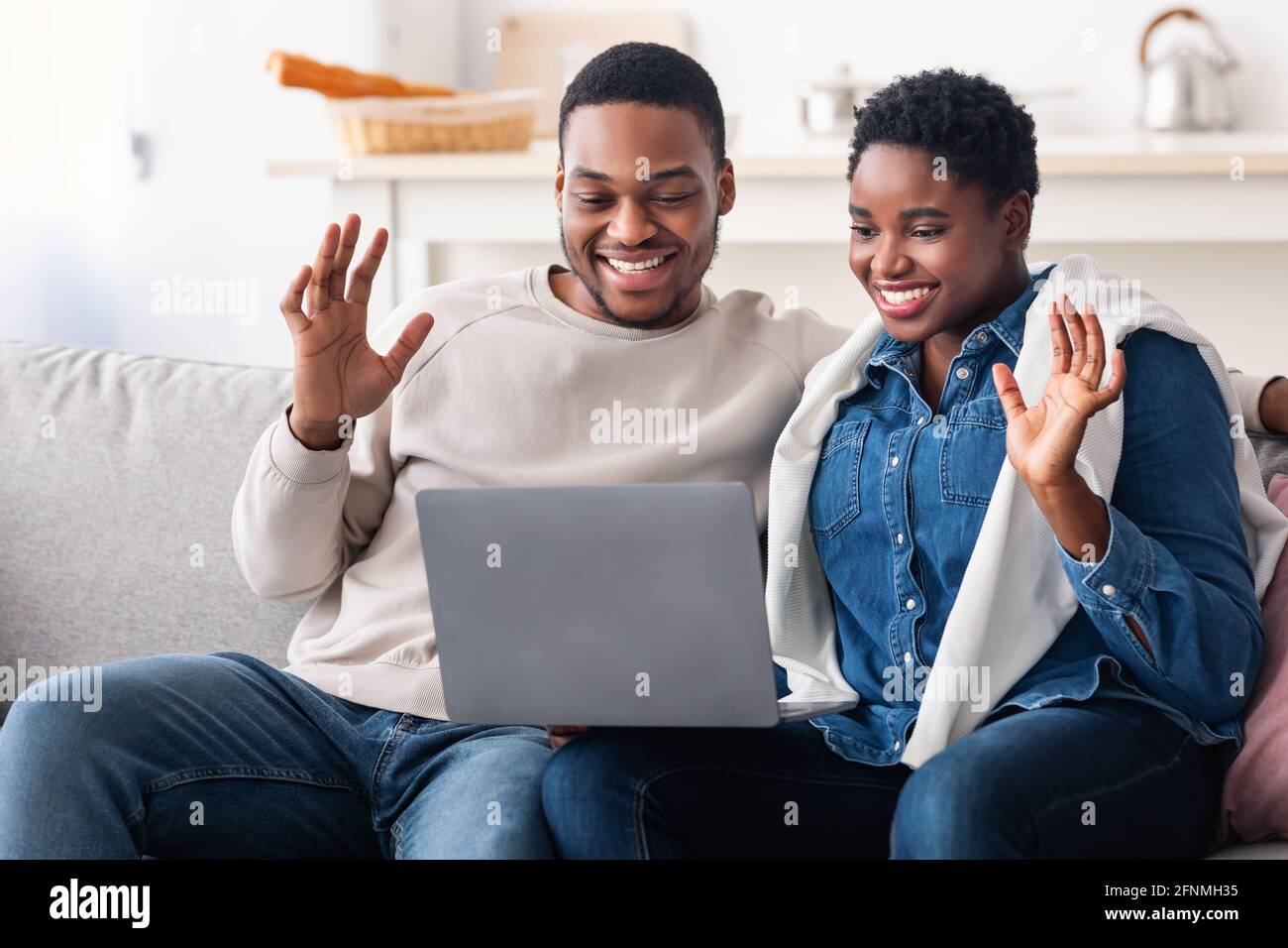Black couple having videocall using laptop waving hands Stock Photo