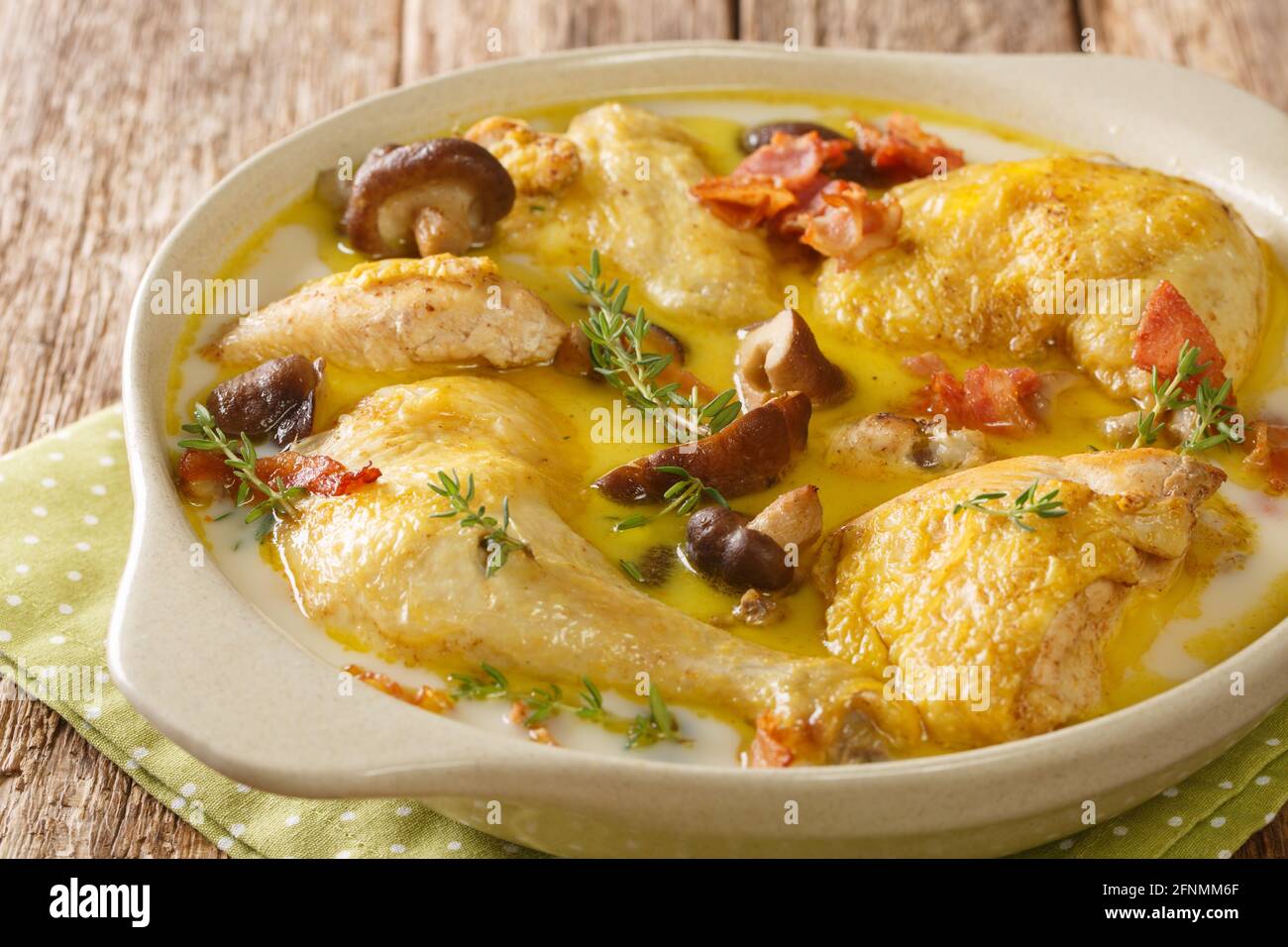 French food Coq au vin Riesling chicken in white wine with cream, bacon and mushrooms close-up in a saucepan on the table. horizontal Stock Photo