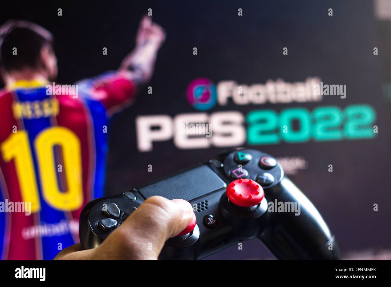 In this photo illustration, a PlayStation (PS) controller and the EFootball Pro  Evolution Soccer (PES 2022) game logo seen in he background. (Photo by  Rafael Henrique / SOPA Images/Sipa USA Stock Photo -