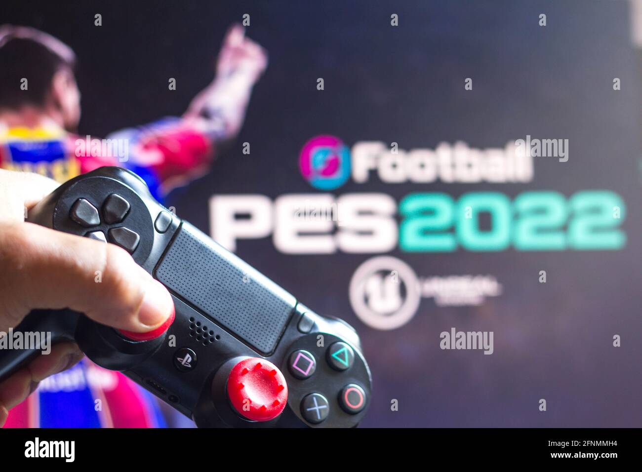 In this photo illustration, a PlayStation (PS) controller and the EFootball Pro  Evolution Soccer (PES 2022) game logo seen in he background. (Photo by  Rafael Henrique / SOPA Images/Sipa USA Stock Photo -