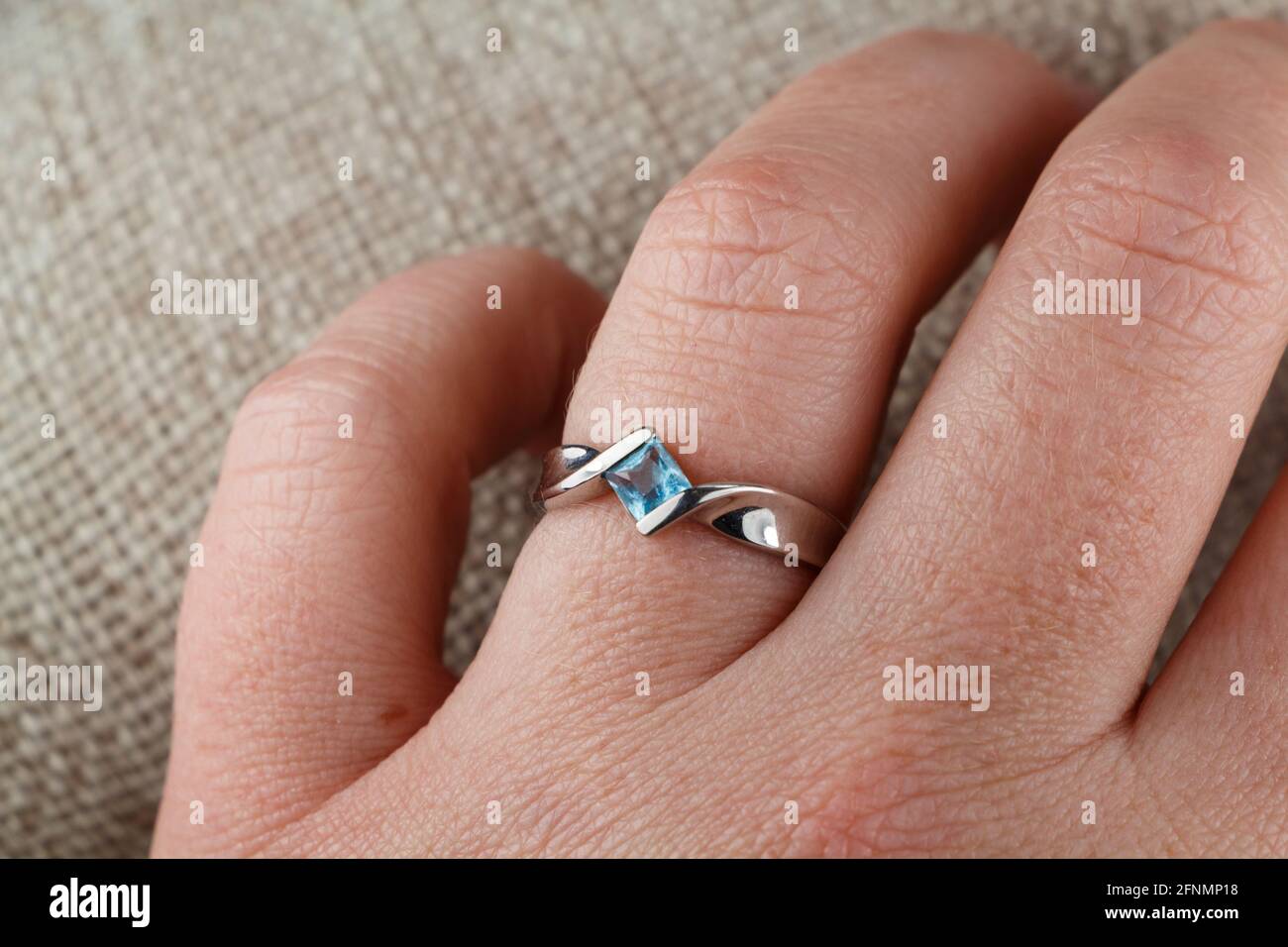 Ring made with white gold and aquamarine on the hand of a woman Stock Photo