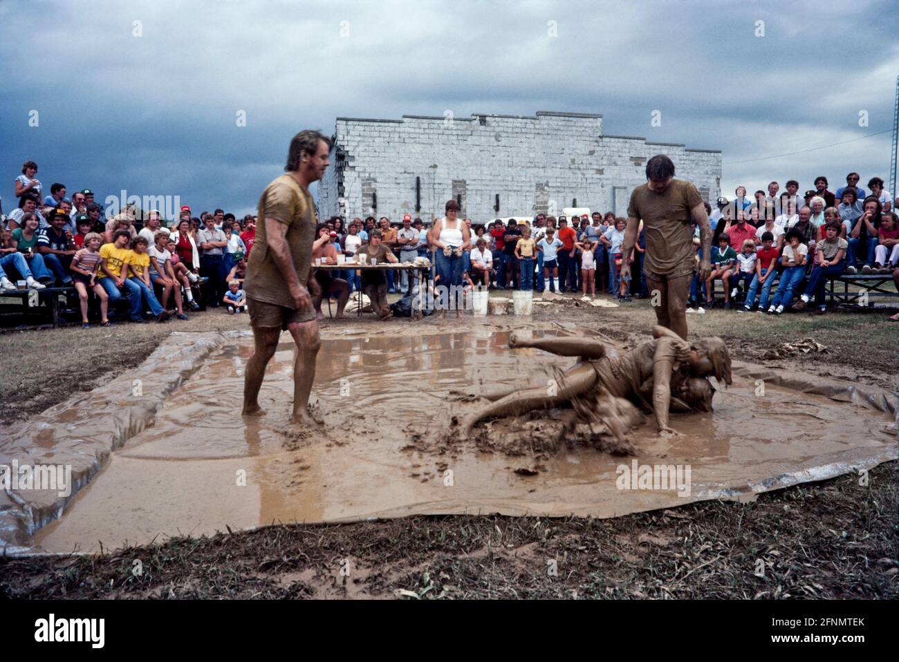 Mud wrestling, Fun in the mud, Muddy fair day goers, Simcoe Ontario Canada 1982. Stock Photo