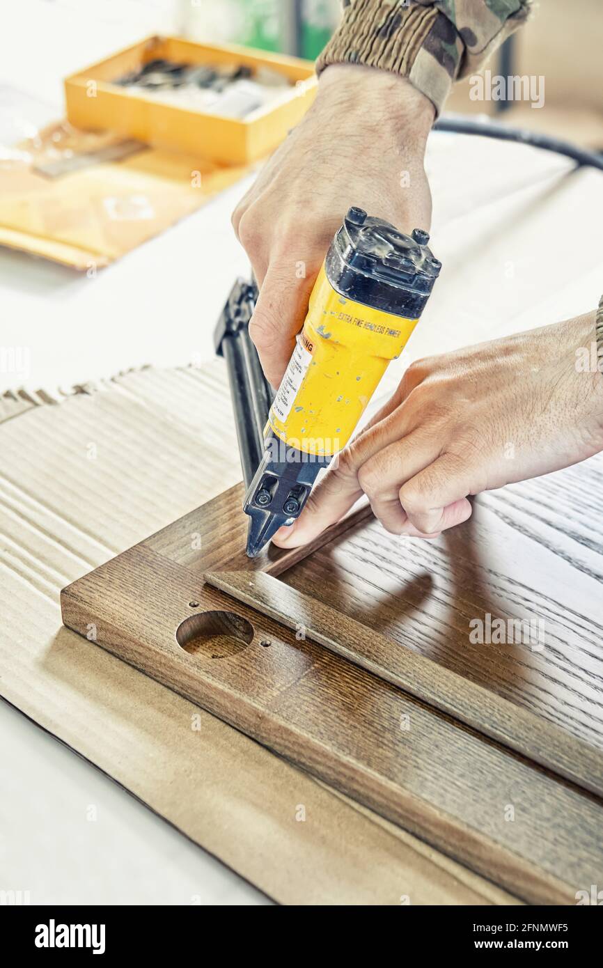 Skilled carpenter assembles wooden door for kitchen fixing