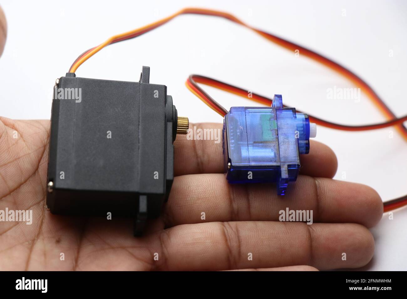 Micro servo and metal geared servo held in hand. Servo which has high