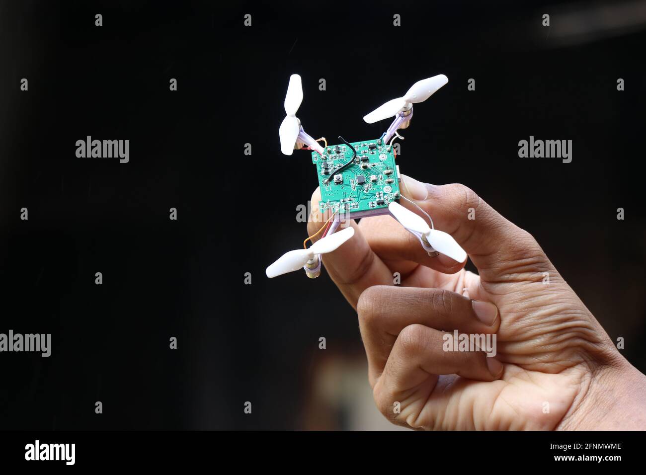 small drone also called by names mini drones or quad copter held in hand. Mini Drone working model held in hand Stock Photo