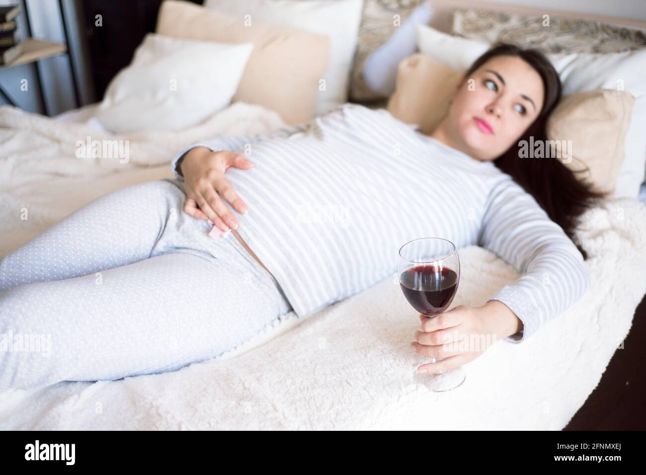 Pregnant woman keeping glass of wine. Future mother drinking alcohol ... - Drinking Wine In Second Trimester
