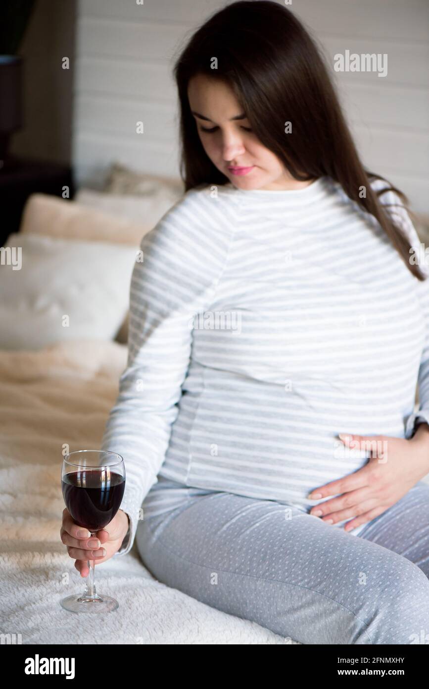Pregnant woman drinking glass of red wine Stock Photo Alamy