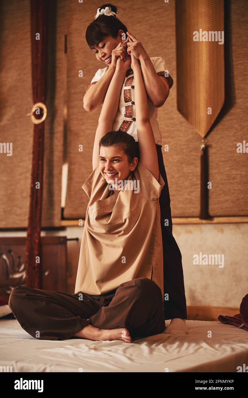 Both massagist and client enjoying Thai massage procedure Stock Photo