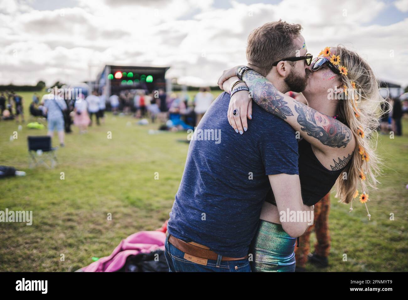 Open air electronic music festival with social distancing measures near Birmingham, the UK. Couple kissing in front of the stage Stock Photo