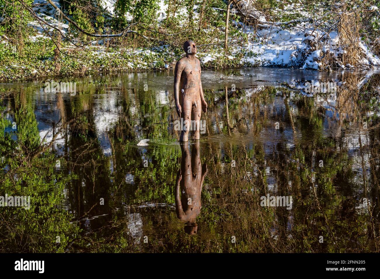 No 2 of six life-size cast iron sculptures by artist Antony Gormley entitled “6 Times” on the Water of Leith in Edinburgh, Scotland, UK Stock Photo