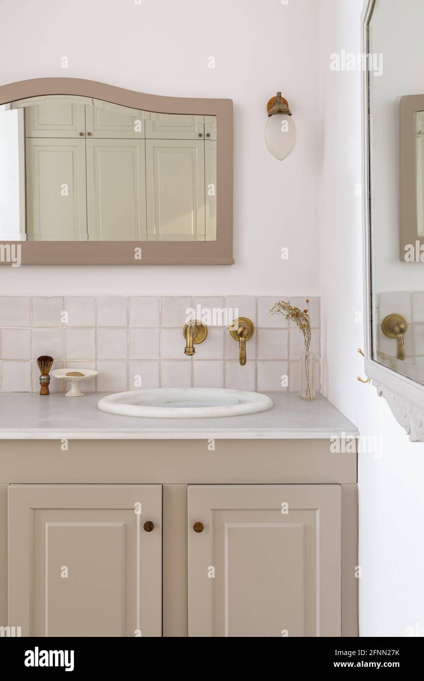 Bathroom decorated in beige color with sinks, golden faucets and