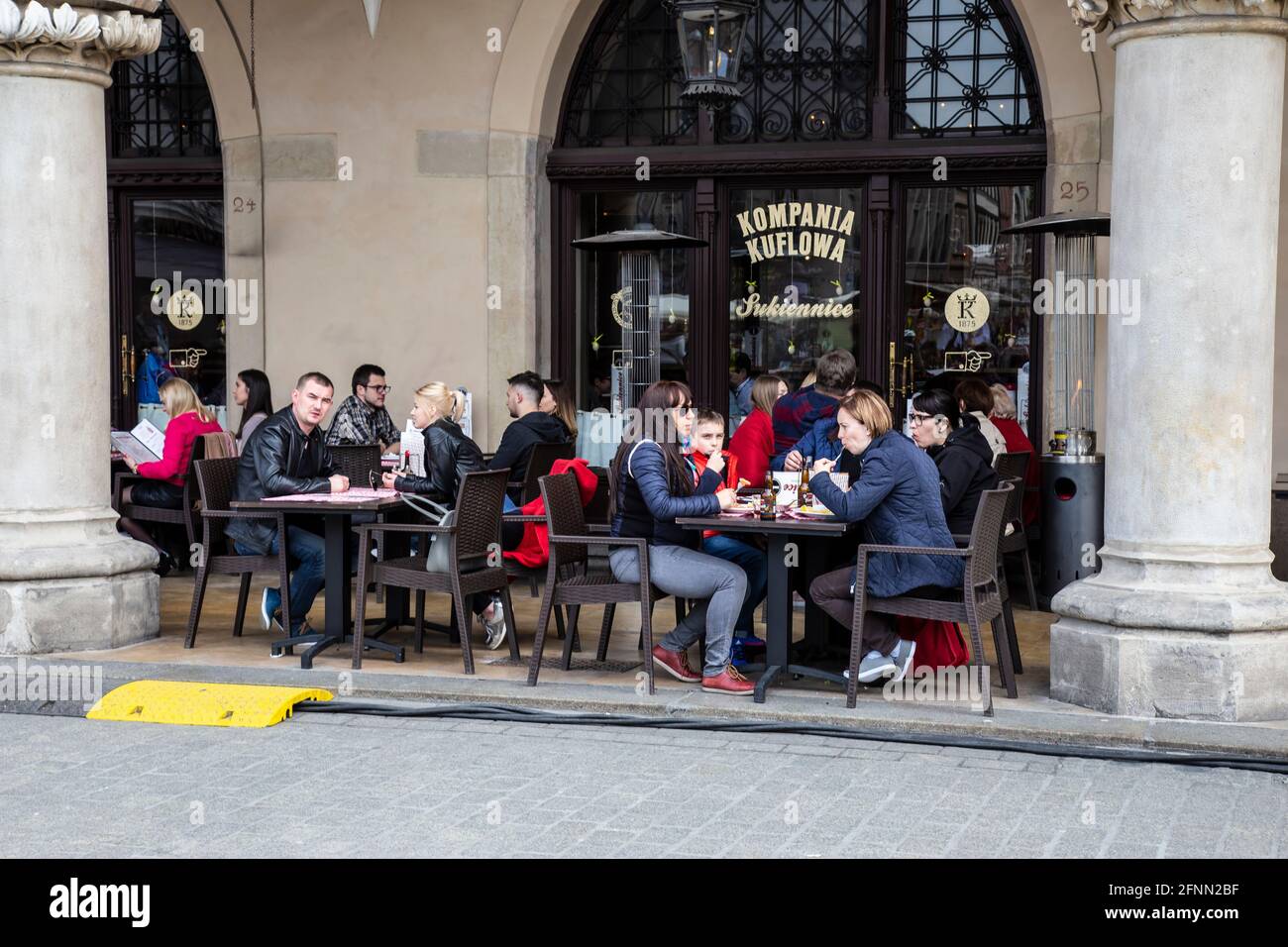 Tourists and local residents enjoying food and drinks under the arches of restaurants and bars