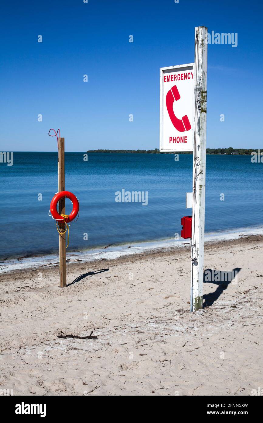 Lifeguard Phone Emergency phone and lifeguard buoy on the beach with blue lagoon at ...