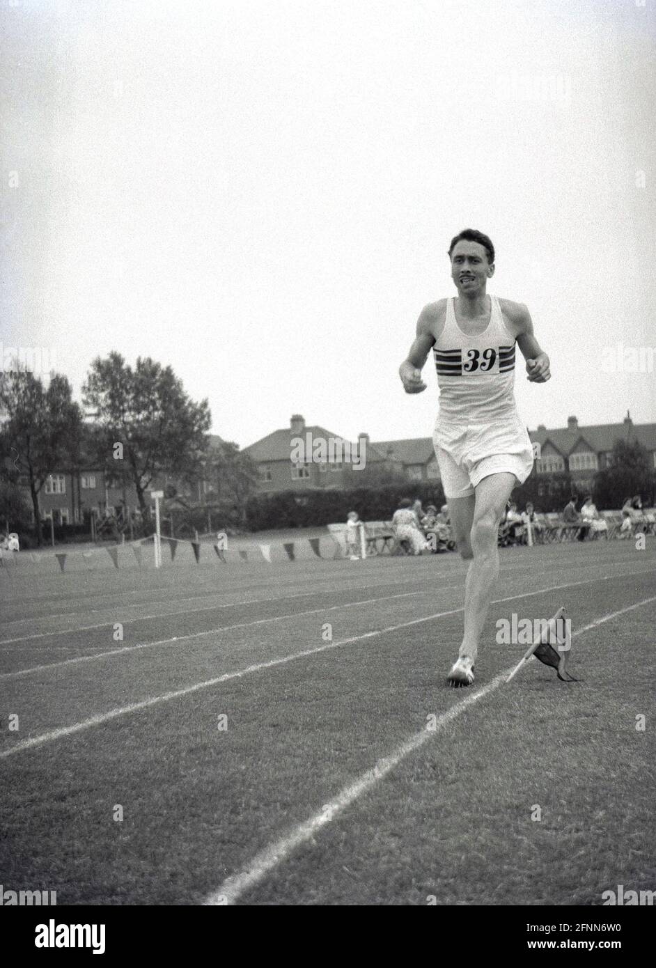 1954, historical, a male competitor outside running on a grass track at a civil service sports day, England, UK, an amateur sports event but competitive nonetheless. Stock Photo
