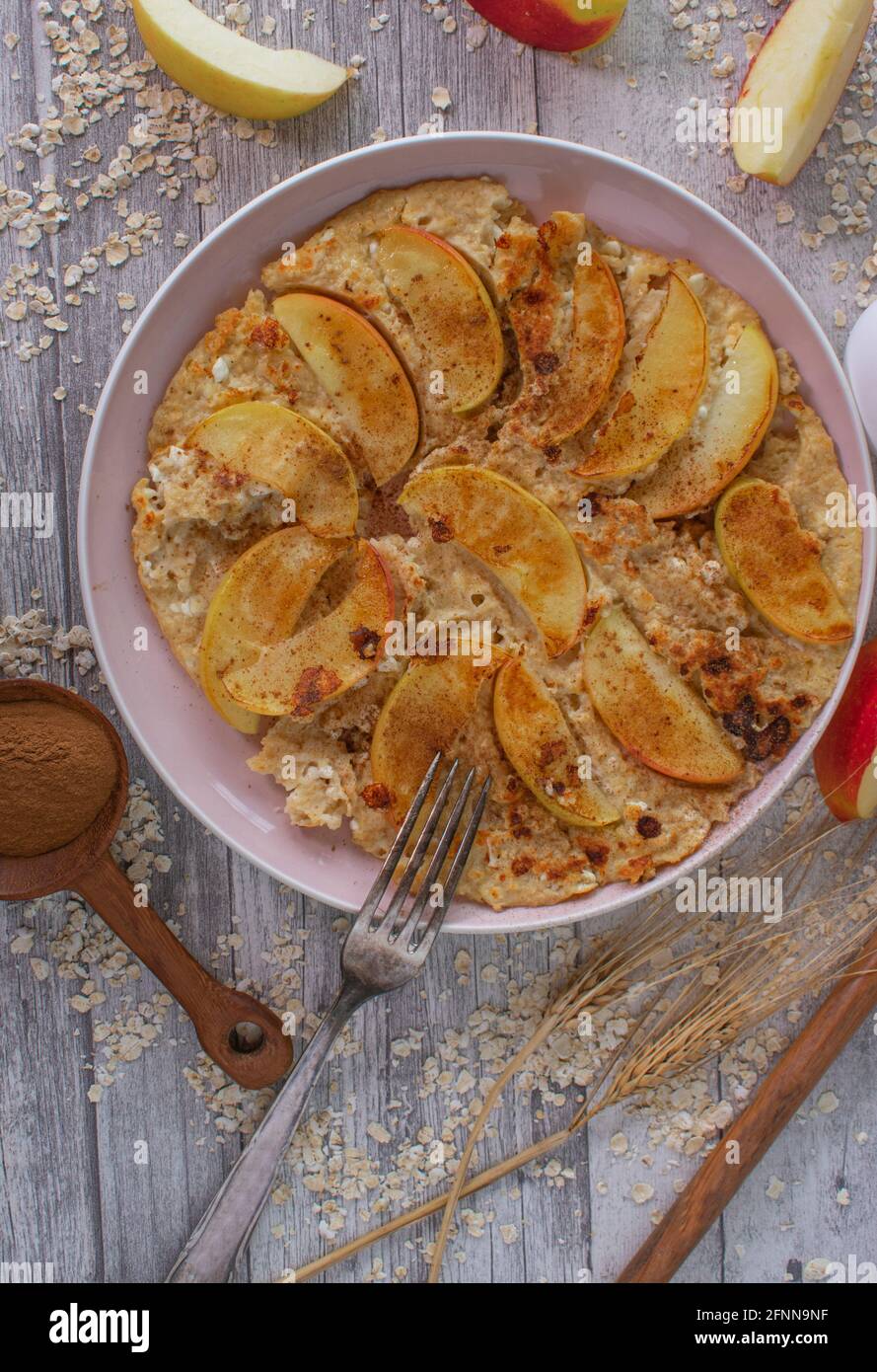 Protein pancake made with gluten free oatmeal, cottage cheese, apples and cinnamon served on a plate with fork on rustic table background Stock Photo