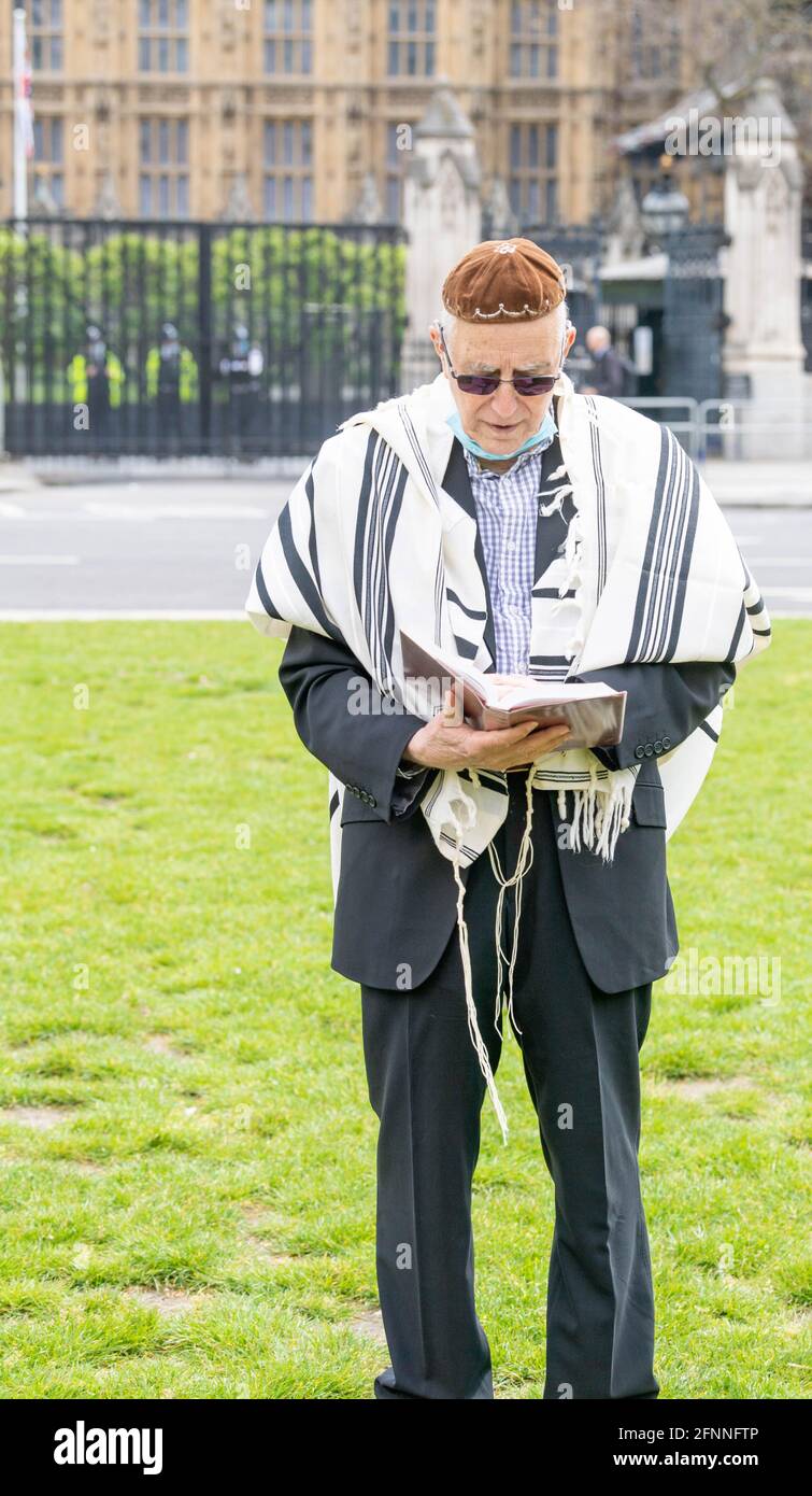 London, UK. 18th May, 2021. Rabbi Jeffery Newman praying outside the House of Commons for an end of the occupation of Paslestine, for the British Government to recognise Palestine and to support the Peoples initiative for Peace. Rabbi Newman is calling for 50% plus 1 British MP's to sign a statement of agreement to his demands. The Rabbi is planning to pray outside Parliment for several days. Credit: Ian Davidson/Alamy Live News Stock Photo