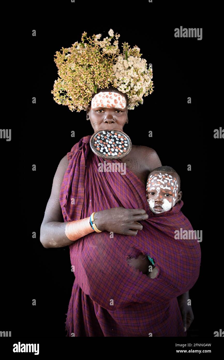With baby and crescent flower-afro, along with a ten-inch lip-plate in tow, this Suri lady is a super-mum. ETHIOPIA: A BRITISH photographer has captur Stock Photo