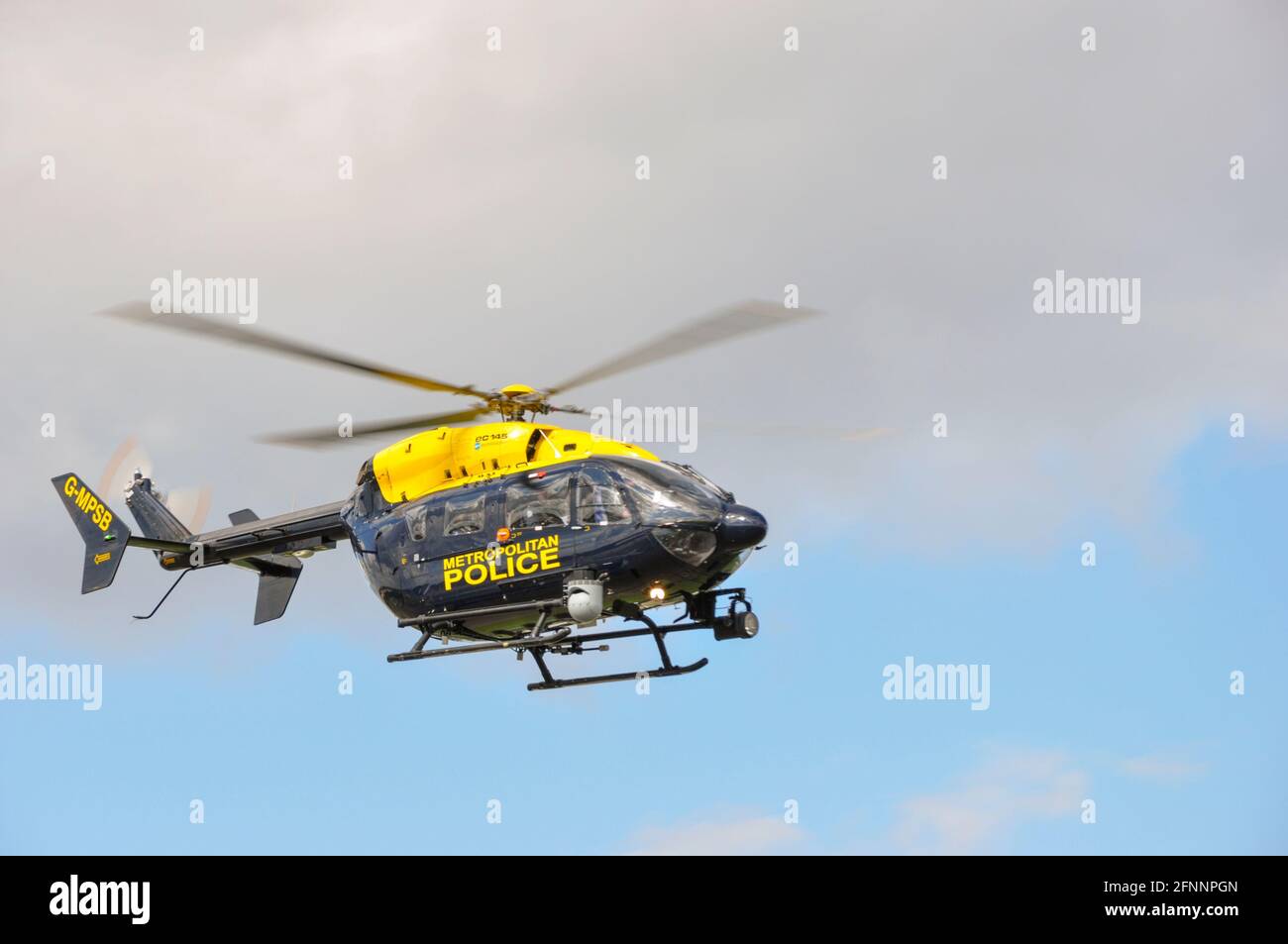 Metropolitan Police helicopter Eurocopter EC145 G-MPSB at North Weald, Essex, UK. Flying in broken cloud. Bright, sunny day. Stock Photo