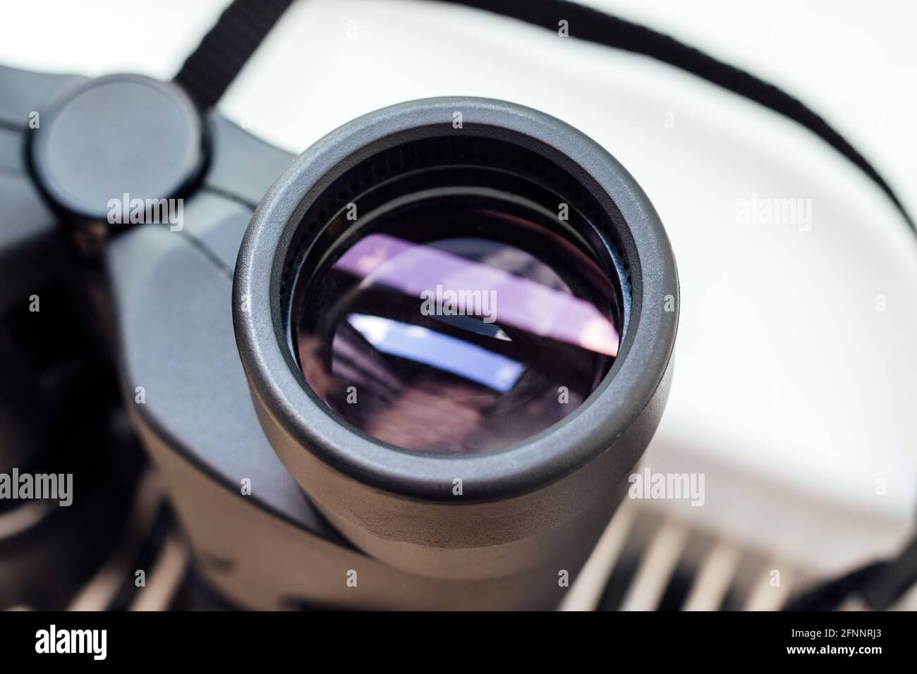 Сloseup view of a binocular lens with a beautiful abstract reflection. Conceptual minimalism, observing environment or nature. Selective focus Stock Photo