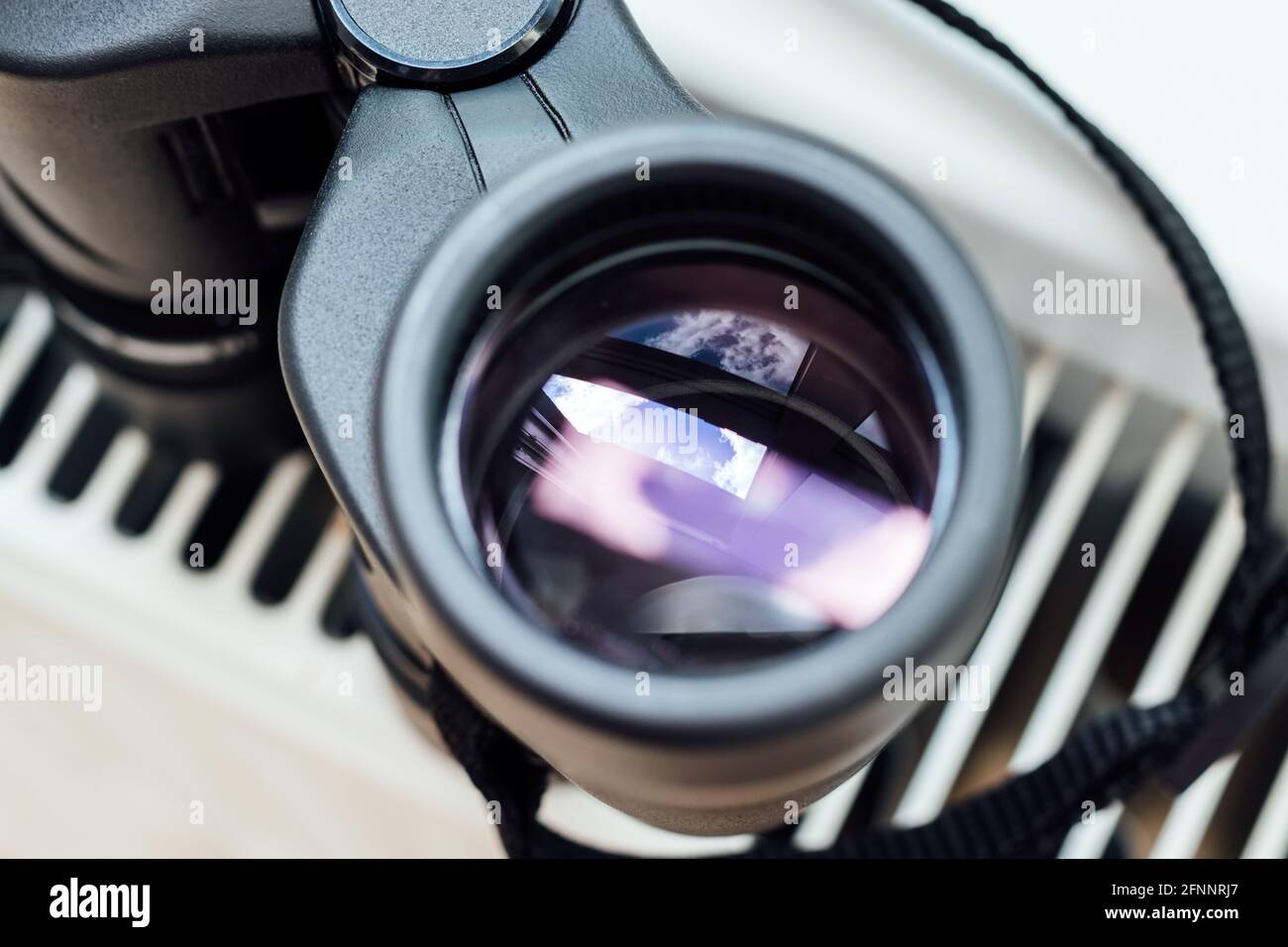 Сloseup view of a binocular lens with a beautiful abstract reflection. Conceptual minimalism, observing environment or nature. Selective focus Stock Photo