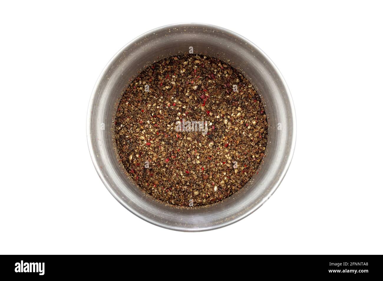 Modern steel pepper grinder with ground pepper mix isolated on white background. Closeup top view. A mix of four types of pepper: black, white, pink, Stock Photo