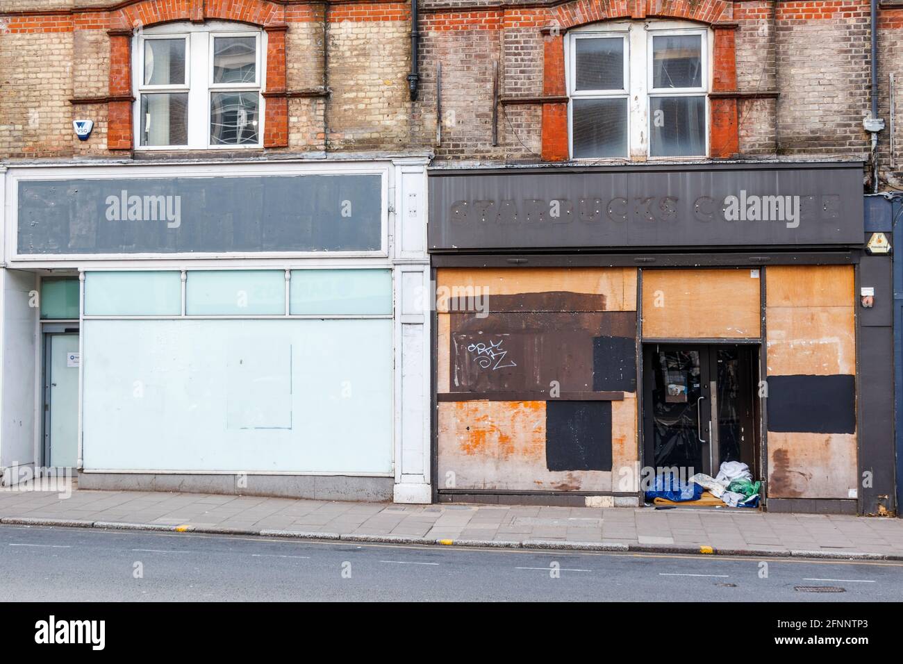 Closed down and boarded up shops in Crouch End, one a Starbucks Coffee