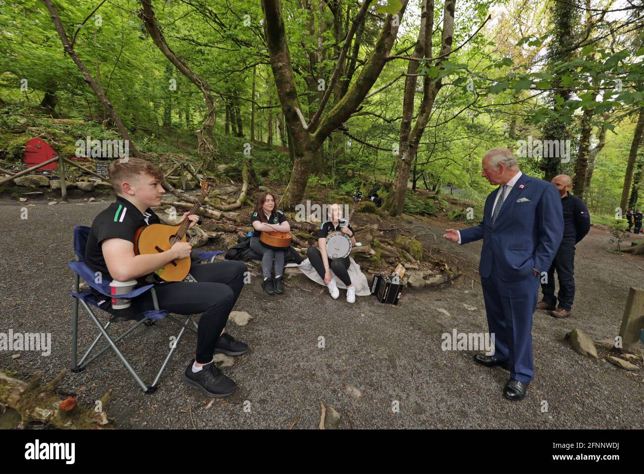 The Prince of Wales talks with (left to right) Brendan O'Sullivan playing bouzouki, Ciara Grant playing bodhran, and Claire Gasey playing banjo, from the the Ring of Gullion Traditional Arts Partnership, during a visit to Slieve Gullion Forest Park in Meigh, Newry. Picture date: Tuesday May 18, 2021. Stock Photo