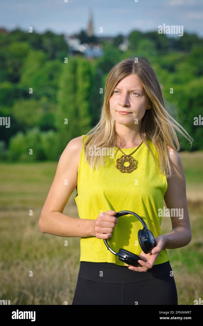 GREAT BRITAIN / England / London / Hampstead Heath / Ecstatic Dance London event . Woman holding silent disco headphones. Stock Photo