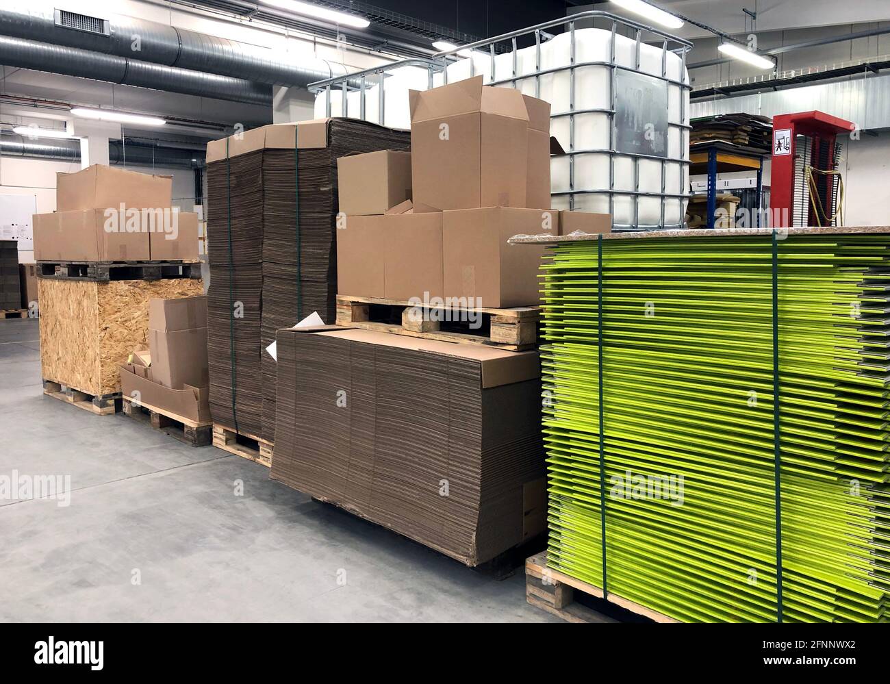 Carton factory or storage with pallets, shelves and stacks of paper and  cardboard for manufacture of advertising Stock Photo - Alamy