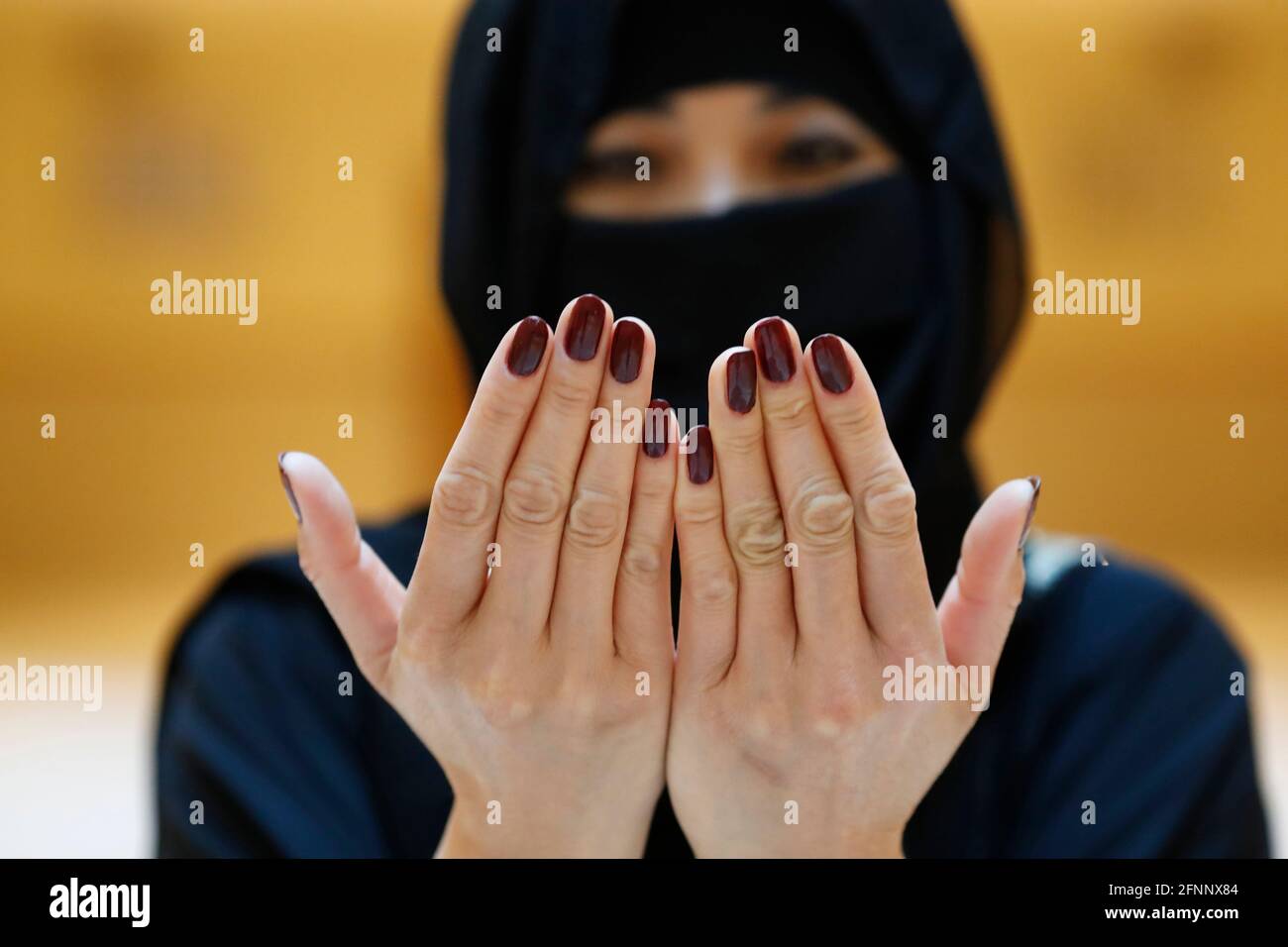 Muslim woman in abaya prays with her hands up in air. Religion praying concept.  United Arab Emirates Stock Photo