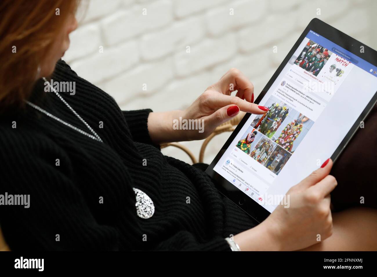 Woman reading  facebook on an Apple iPad digital tablet.  Facebook social media app.  France. Stock Photo