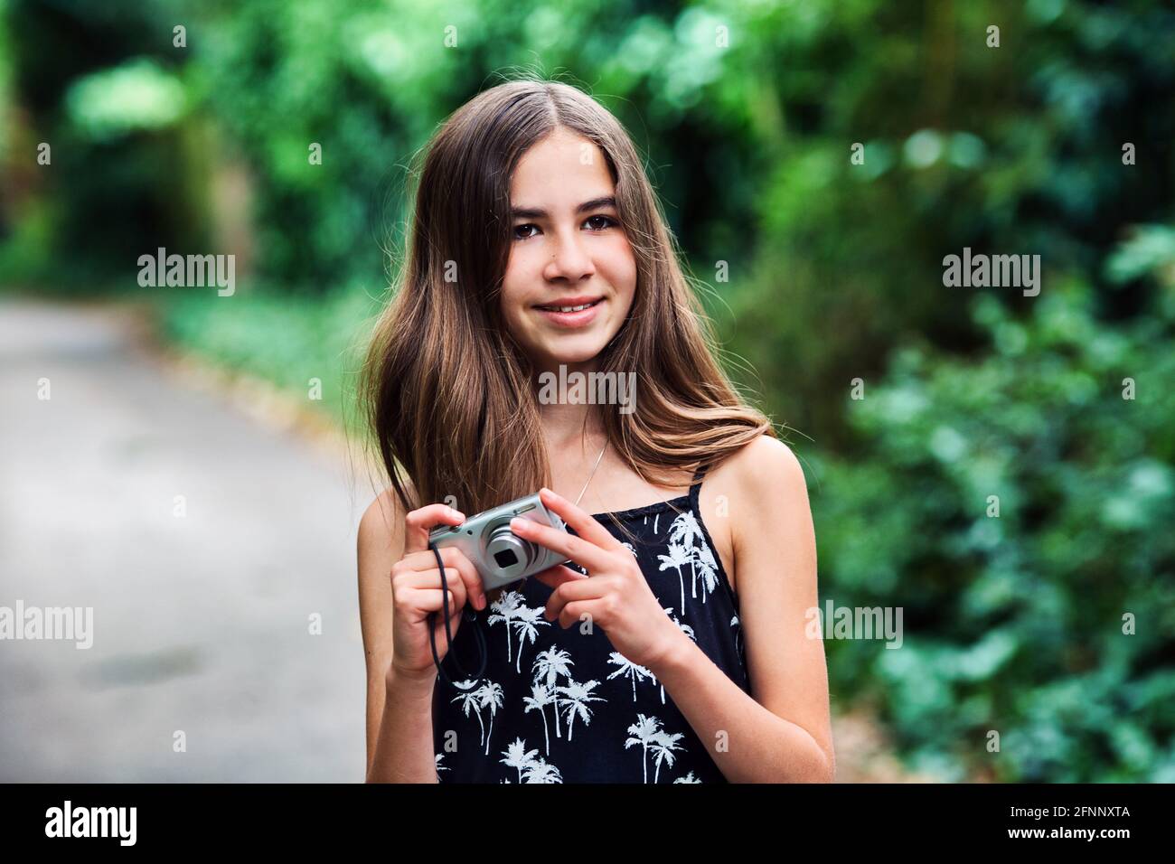 young girl holding camera at outside Stock Photo