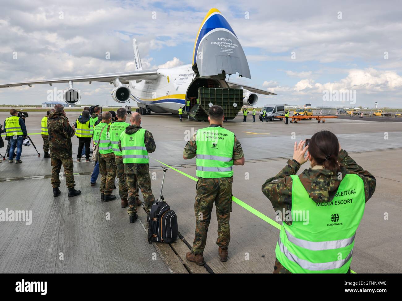 Schkeuditz, Germany. 18th May, 2021. Bundeswehr soldiers film and  photograph the unloading of NH90 transport helicopters from an AN-124  wide-body transport aircraft at Leipzig/Halle Airport. The landing of the  first aircraft carrying