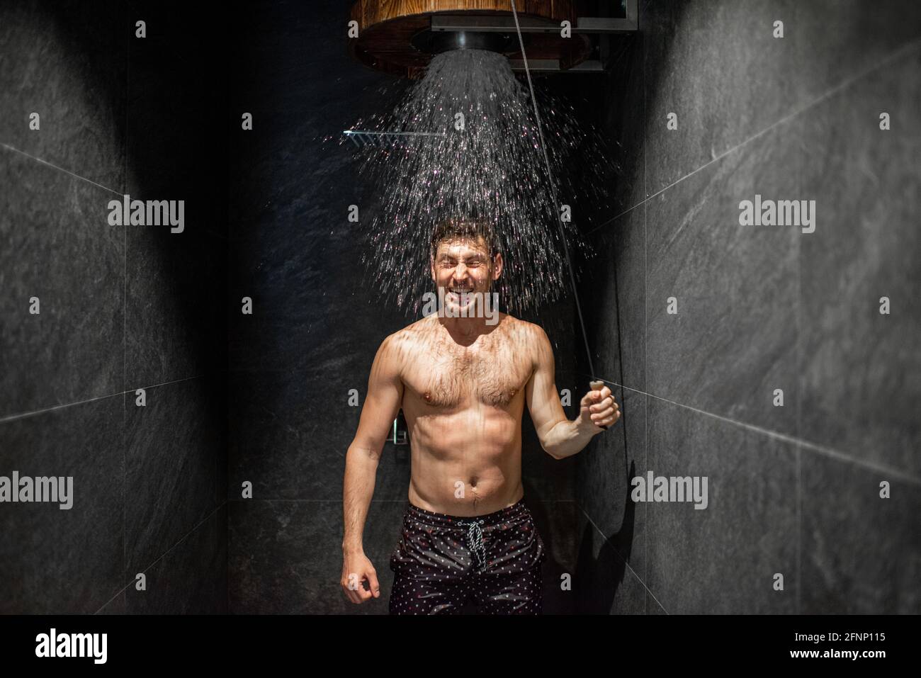 Man hardening with bucket of ice cold water after hot sauna, healthy lifestyle and cold training concept. Wellness and spa. Stock Photo