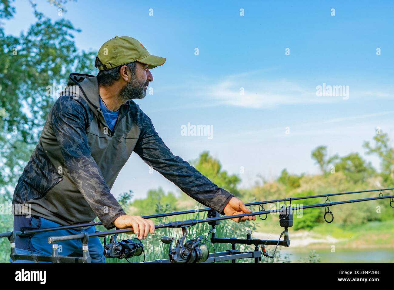 man preparing fishing equipment for a carp fishing session on the rive Stock Photo