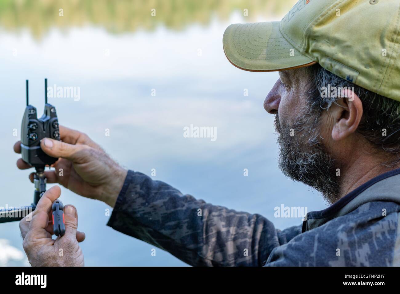 man preparing fishing equipment for a carp fishing session on the rive Stock Photo
