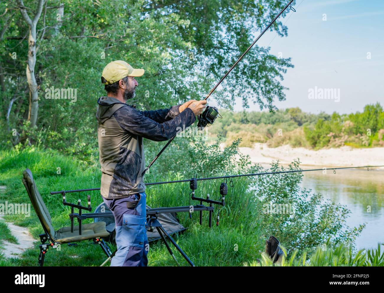 https://c8.alamy.com/comp/2FNP2J5/man-preparing-fishing-equipment-for-a-carp-fishing-session-on-the-rive-2FNP2J5.jpg