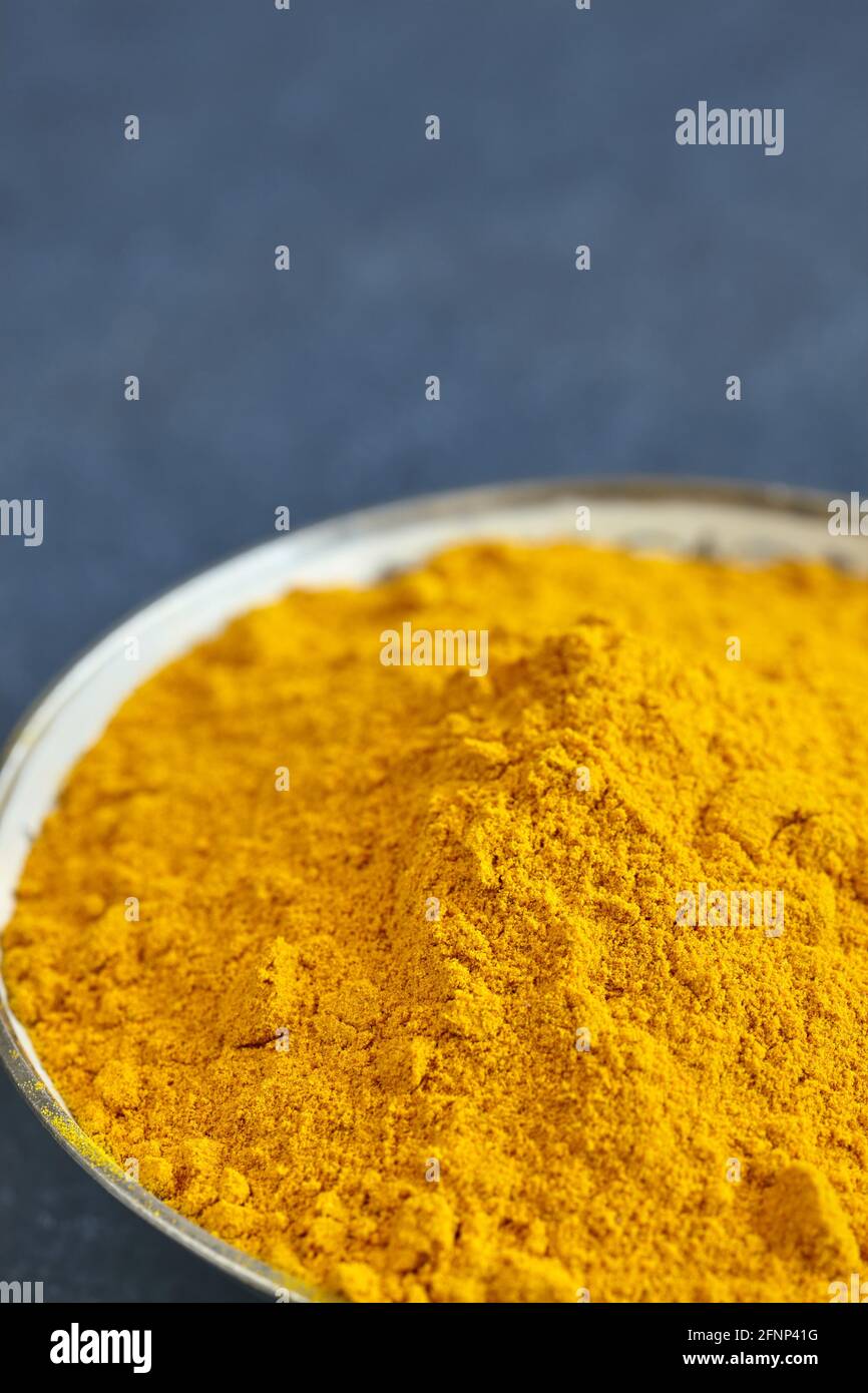 Close up picture of turmeric powder in a bowl, shallow depth of field, space for text. Stock Photo