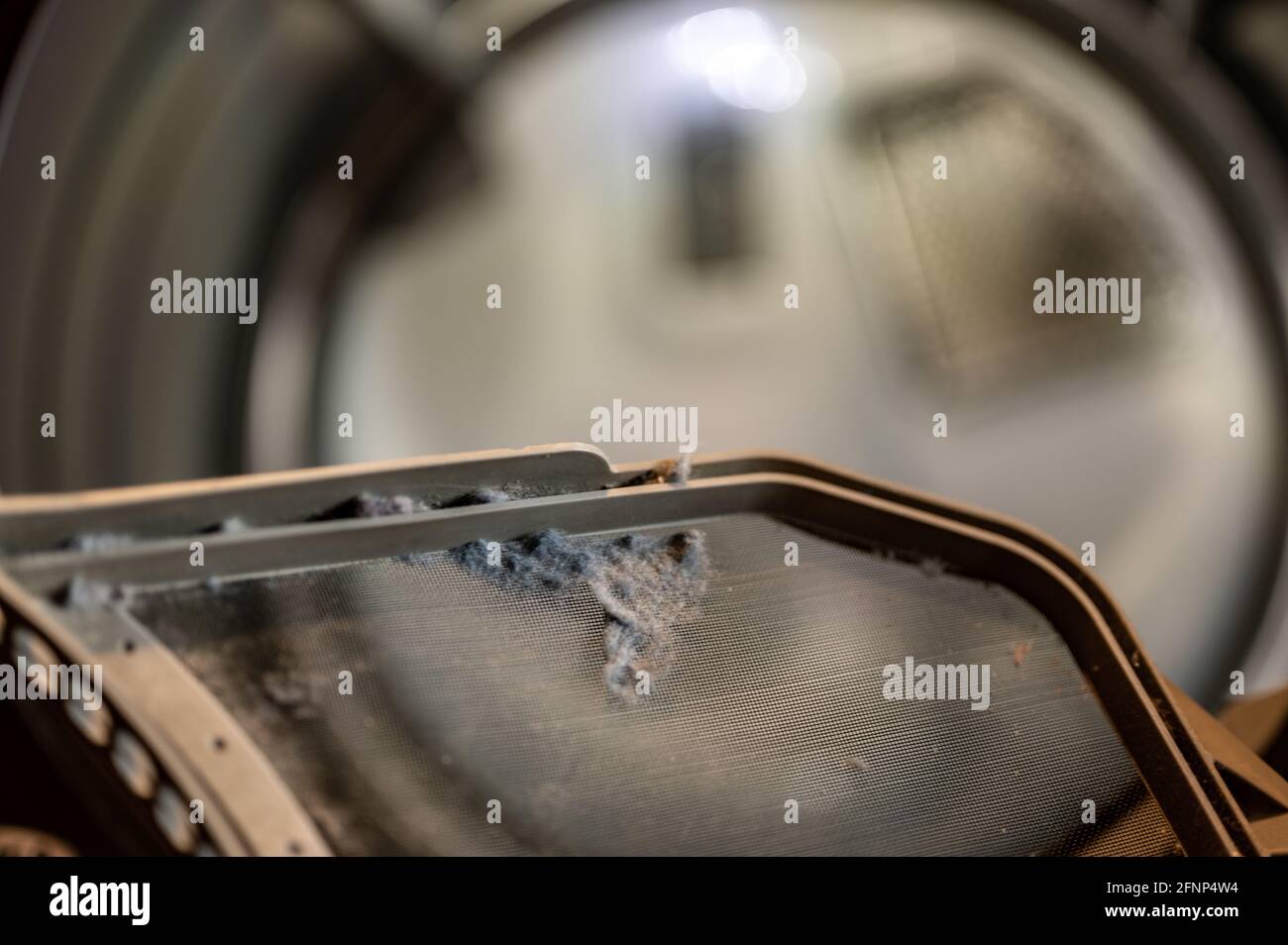 Dryer lint trap pulled to remove buildup after each cycle Stock Photo