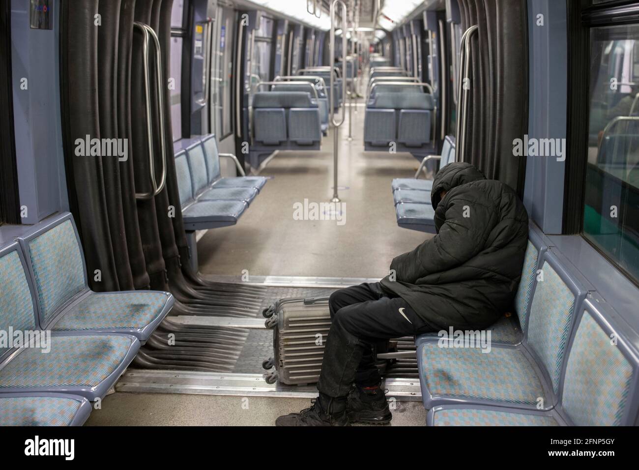 Homeless man sleeping in a Paris subway car, France Stock Photo