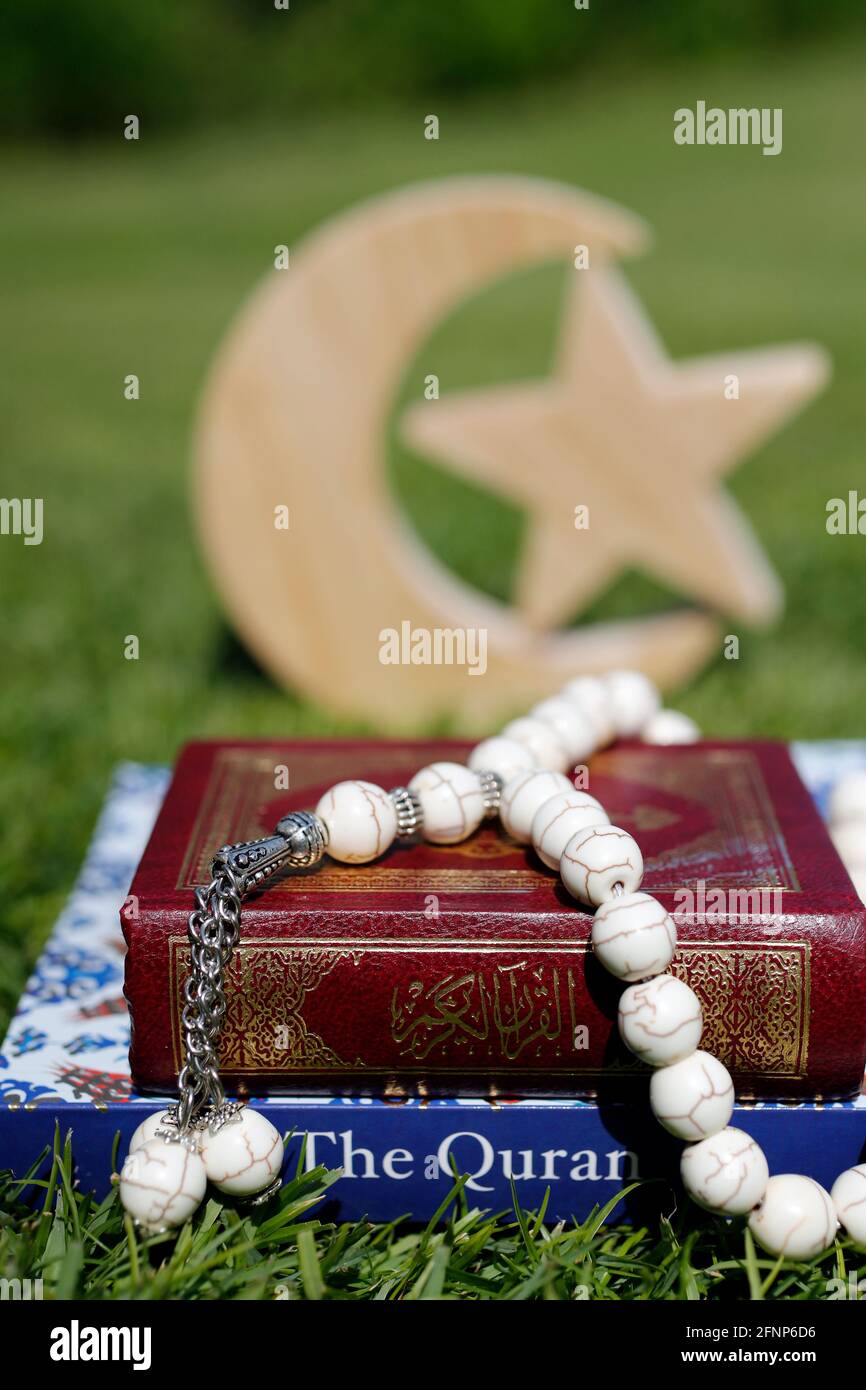 Prayer beads ( misbaha ) with Quran in arabic and english and crescent and star. Symbols of Islam.  United Arab Emirates Stock Photo