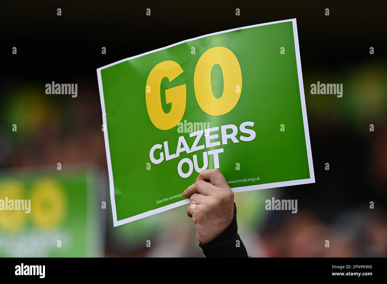 A Manchester United fan holds up a protest poster during the Premier League match at Old Trafford, Manchester. Picture date: Tuesday May 18, 2021. Stock Photo