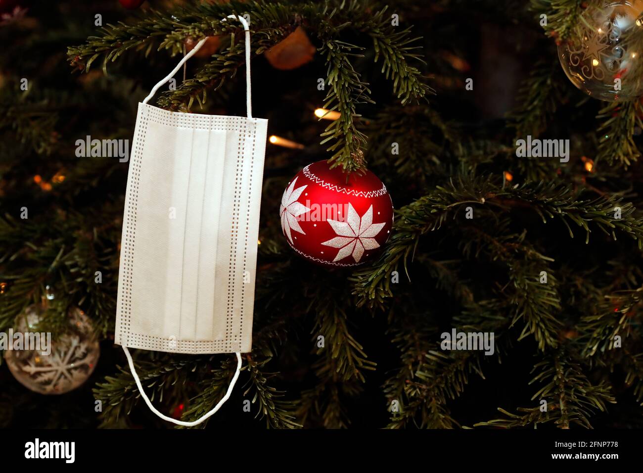Christmas tree with decorations and surgical mask. Covid 19 pandemic.  Geneva. Switzerland Stock Photo - Alamy