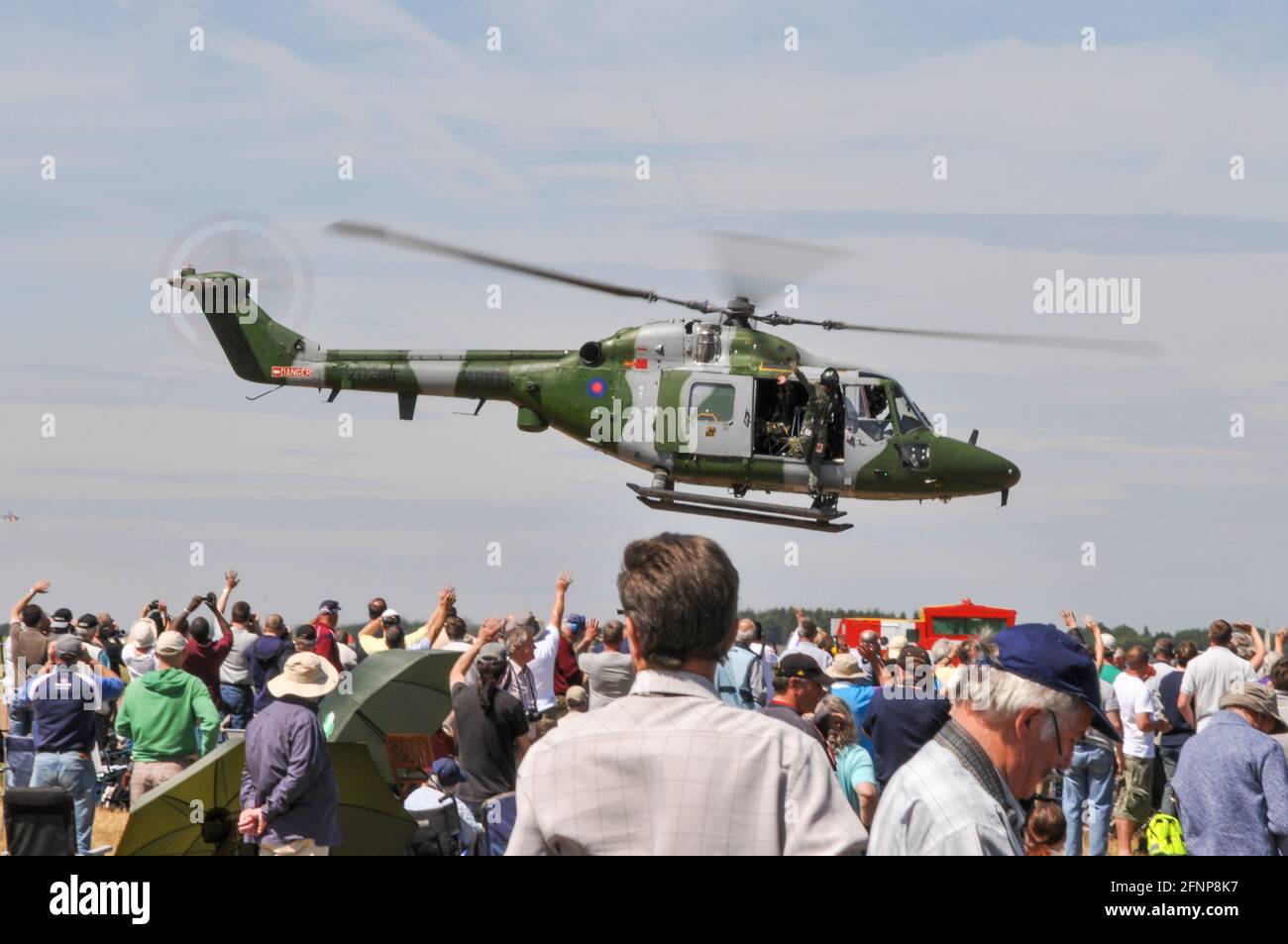 British Army, Army Air Corps Westland Lynx AH.7 helicopter ZD284 departing at Royal International Air Tattoo, RIAT, RAF Fairford, UK. Crowd waving Stock Photo
