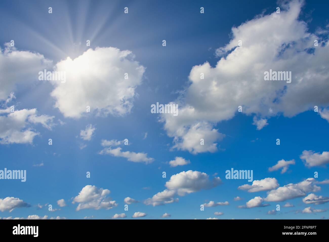 cloudy blue sky background with sun rays Stock Photo