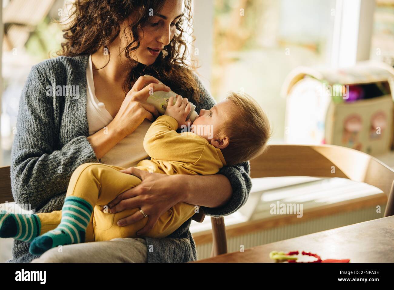 Newborn Baby Drinking Milk From Bottle Cute Toddler In Mother s Arms newborn-baby-drinking-milk-from-bottle-cute-toddler-in-mother-s-arms