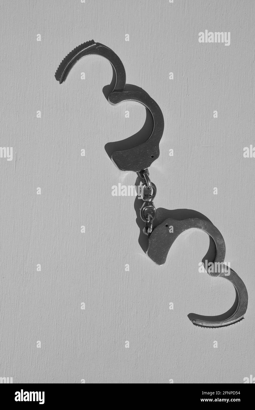 Directly above of open unlocked handcuffs isolated on grey background. Concept of escape, kinky, crime, restraining, punishment Stock Photo